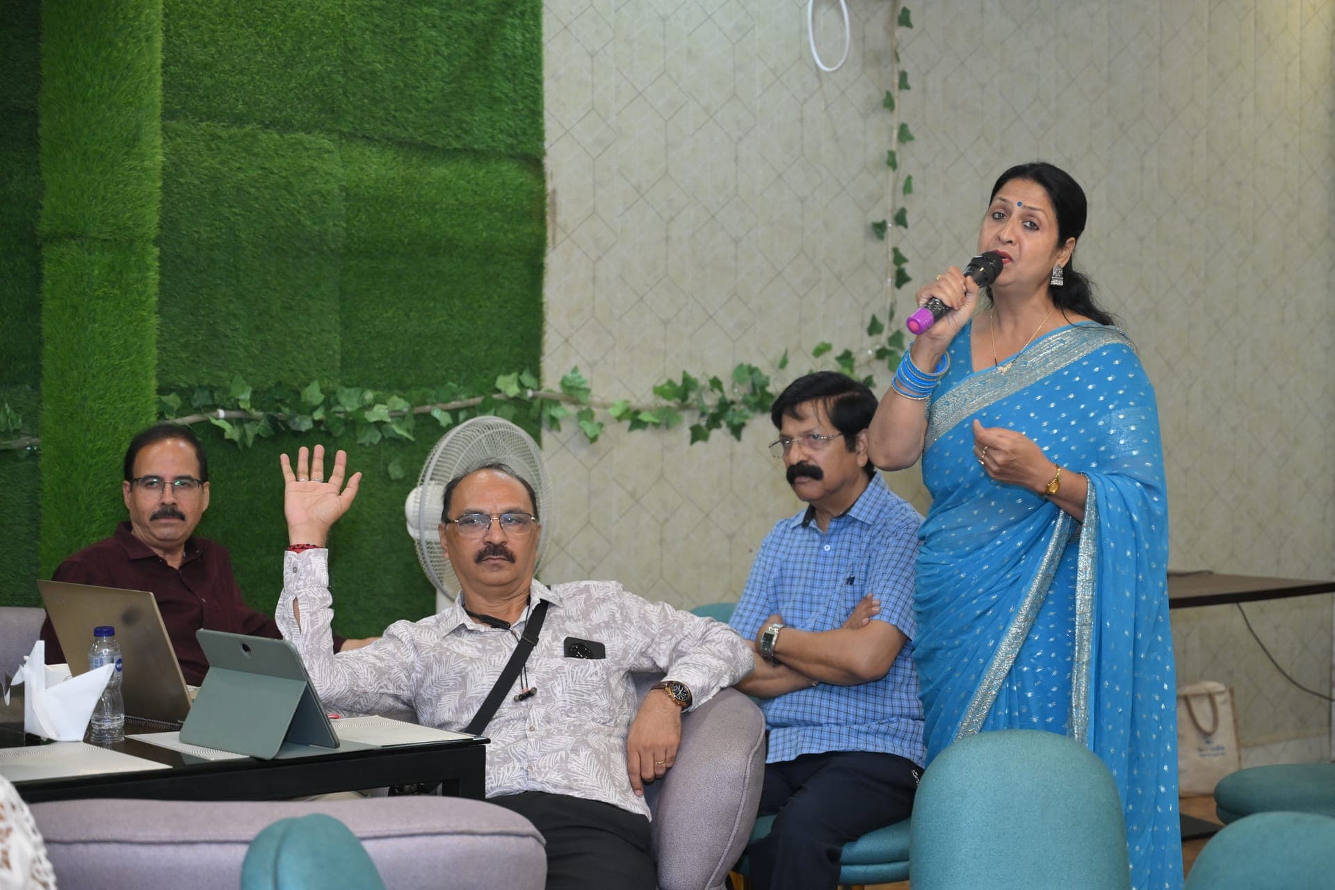 A guest speaking at a gathering with a microphone